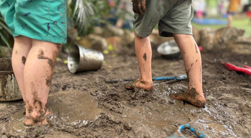 Children walking barefooted in mud