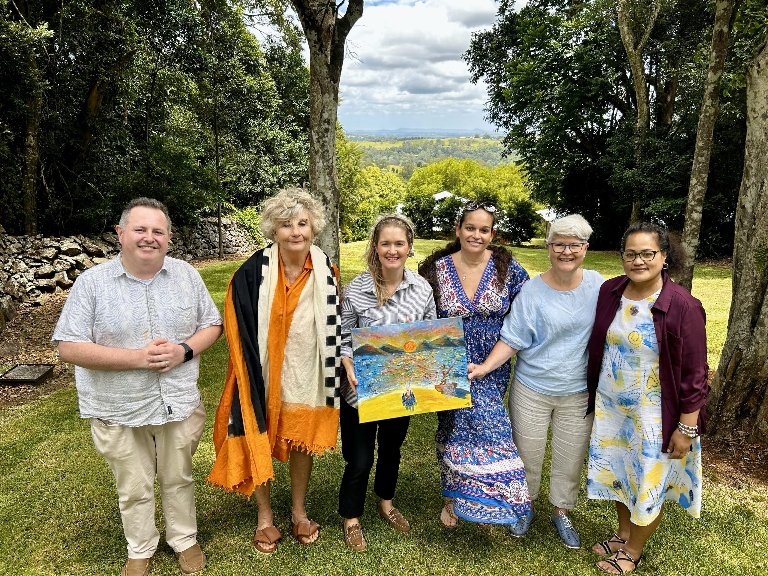 Group of people holding artwork outdoors.