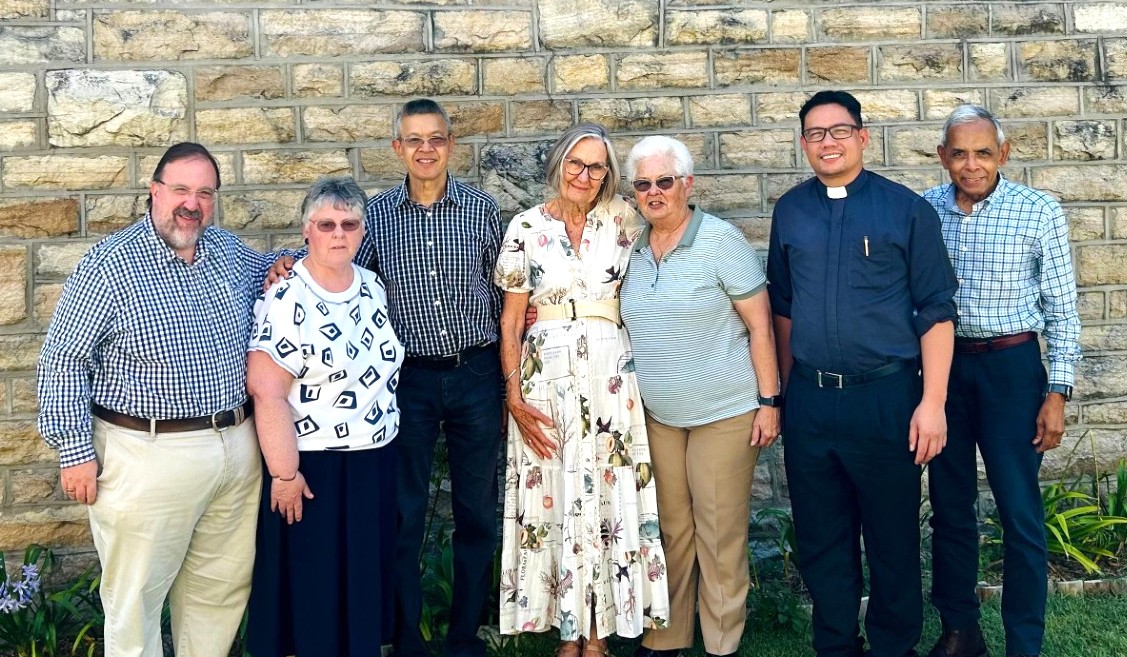 Group of people posing together outdoors.