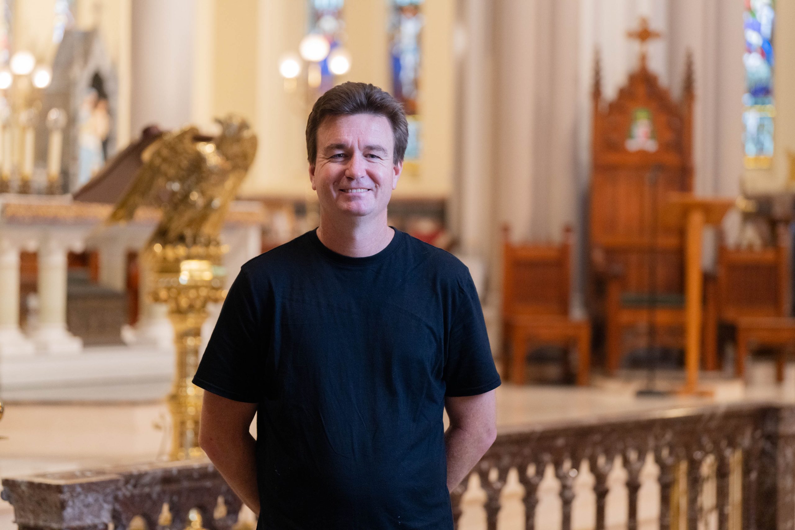 Man standing in a cathedral interior.